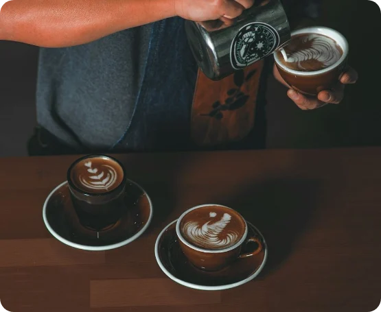 Barista training program in Qatar – pouring latte art into specialty coffee cups